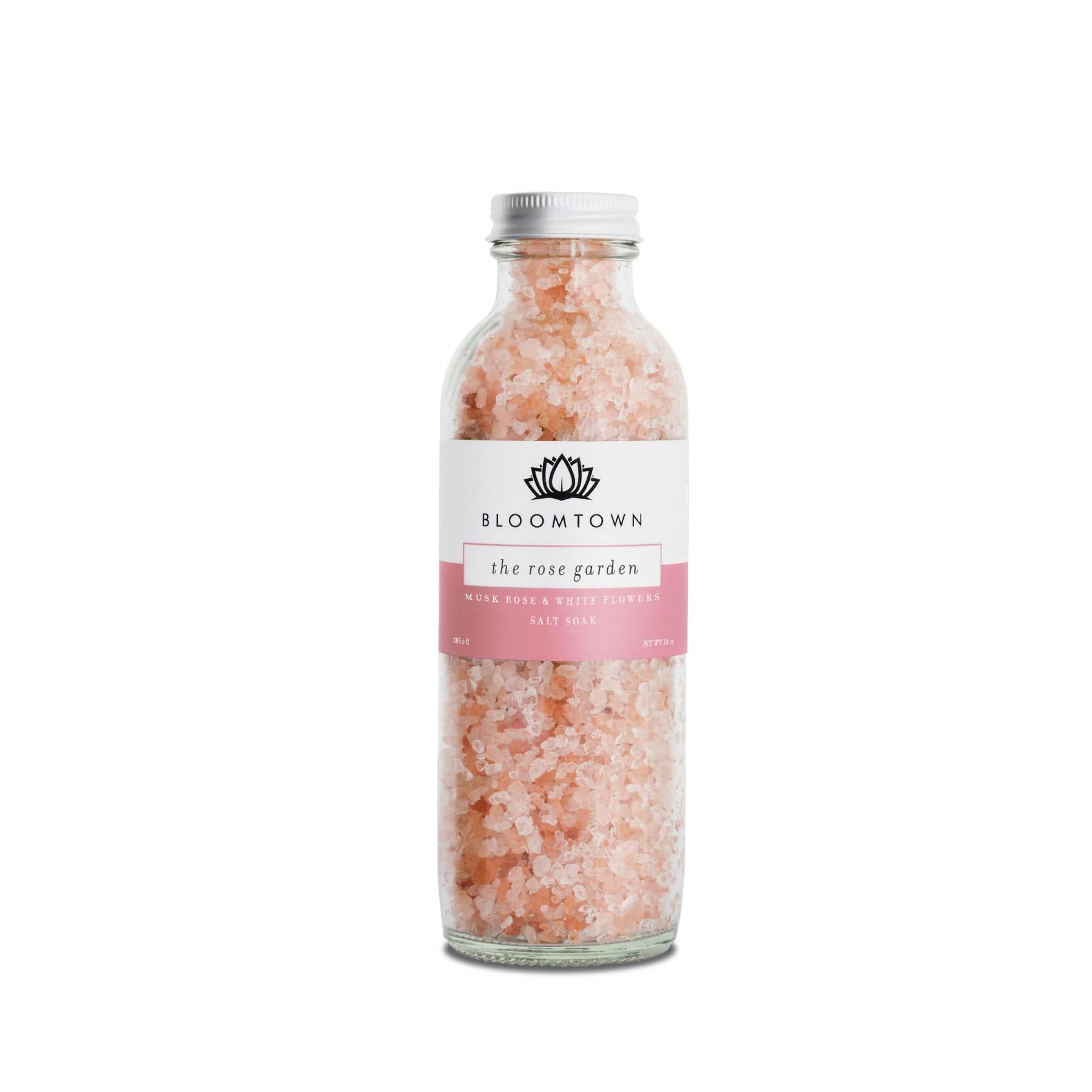 Bloomtown The Rose Garden salt soak bottle with musk rose and white flowers, pink bath salts in clear glass packaging on a white background.