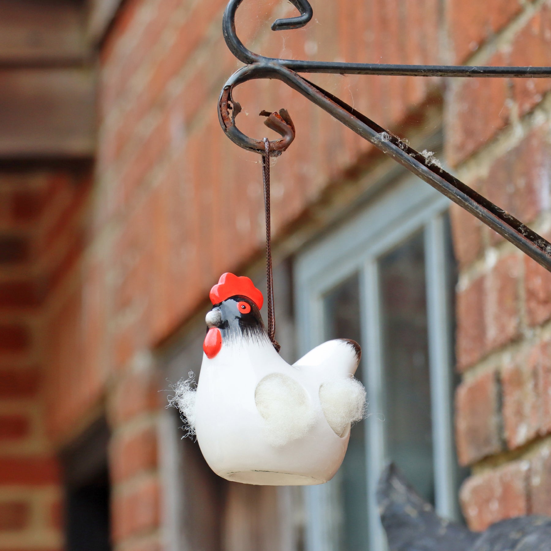 'Cluckie' hanging ceramic hen with nesting wool