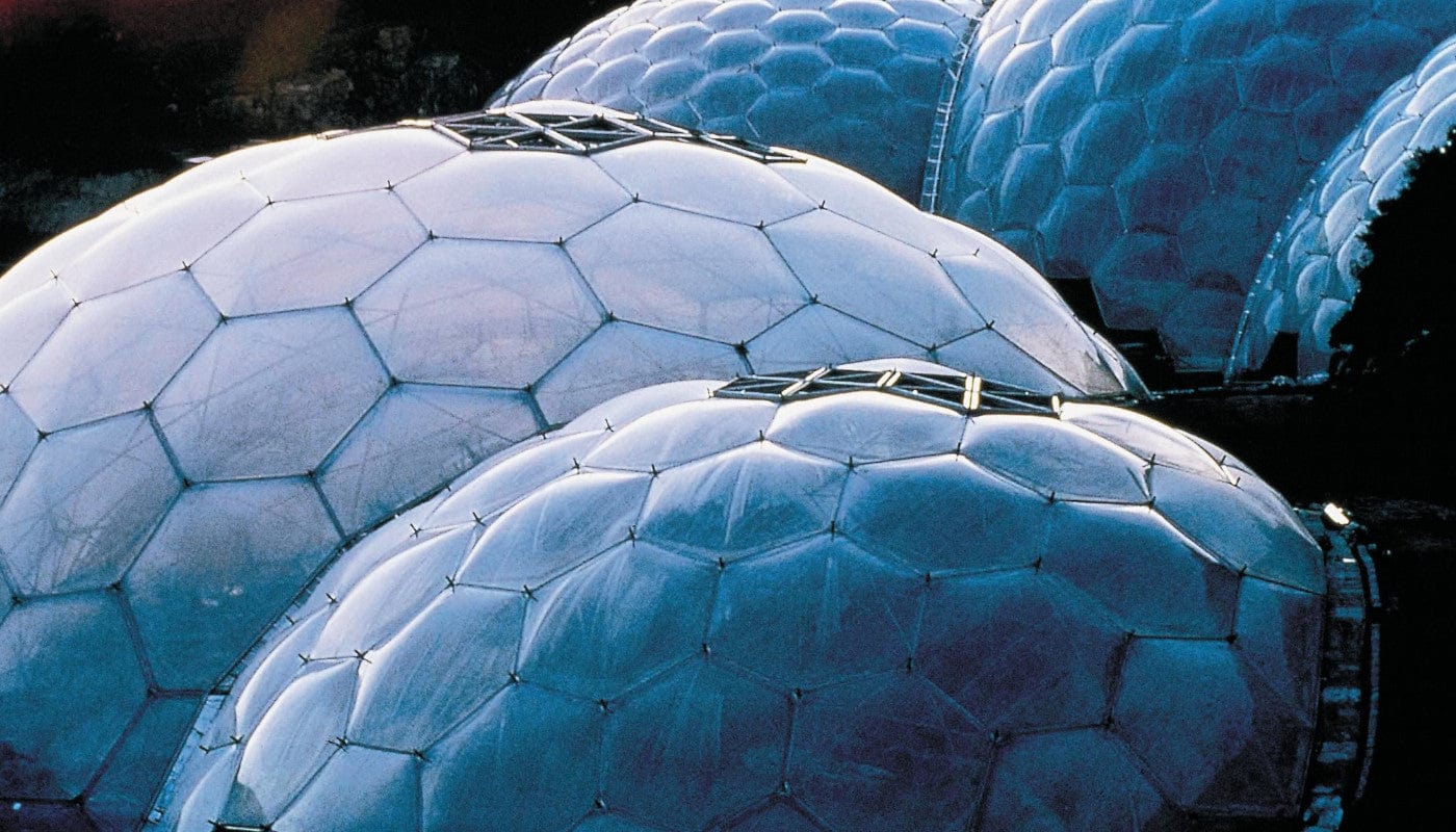 Geodesic domes clustered together, futuristic architecture, eco-friendly biome conservatories, hexagonal transparent panels, innovative design, sustainable building