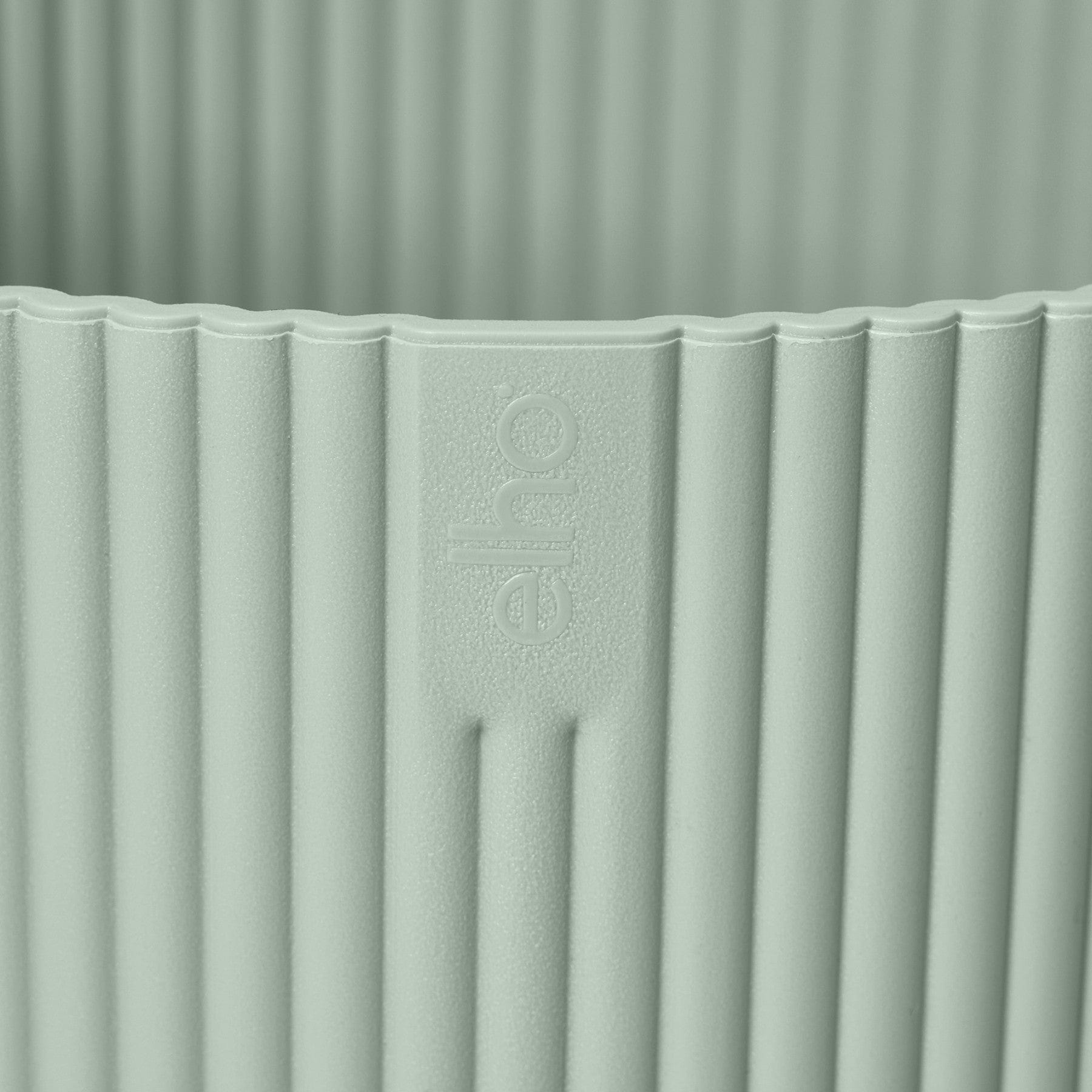 Close-up of a green textured surface with embossed "echo" brand logo, vertical lines pattern design detail.