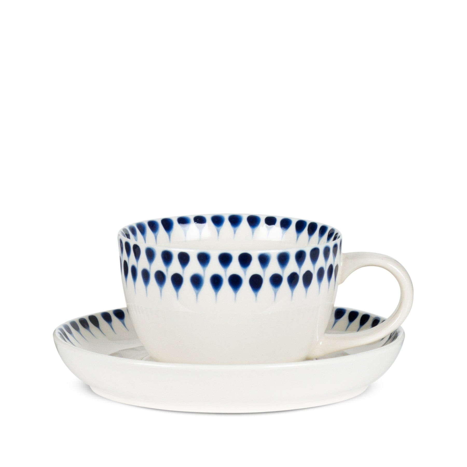 Porcelain teacup and saucer with blue teardrop pattern on white background