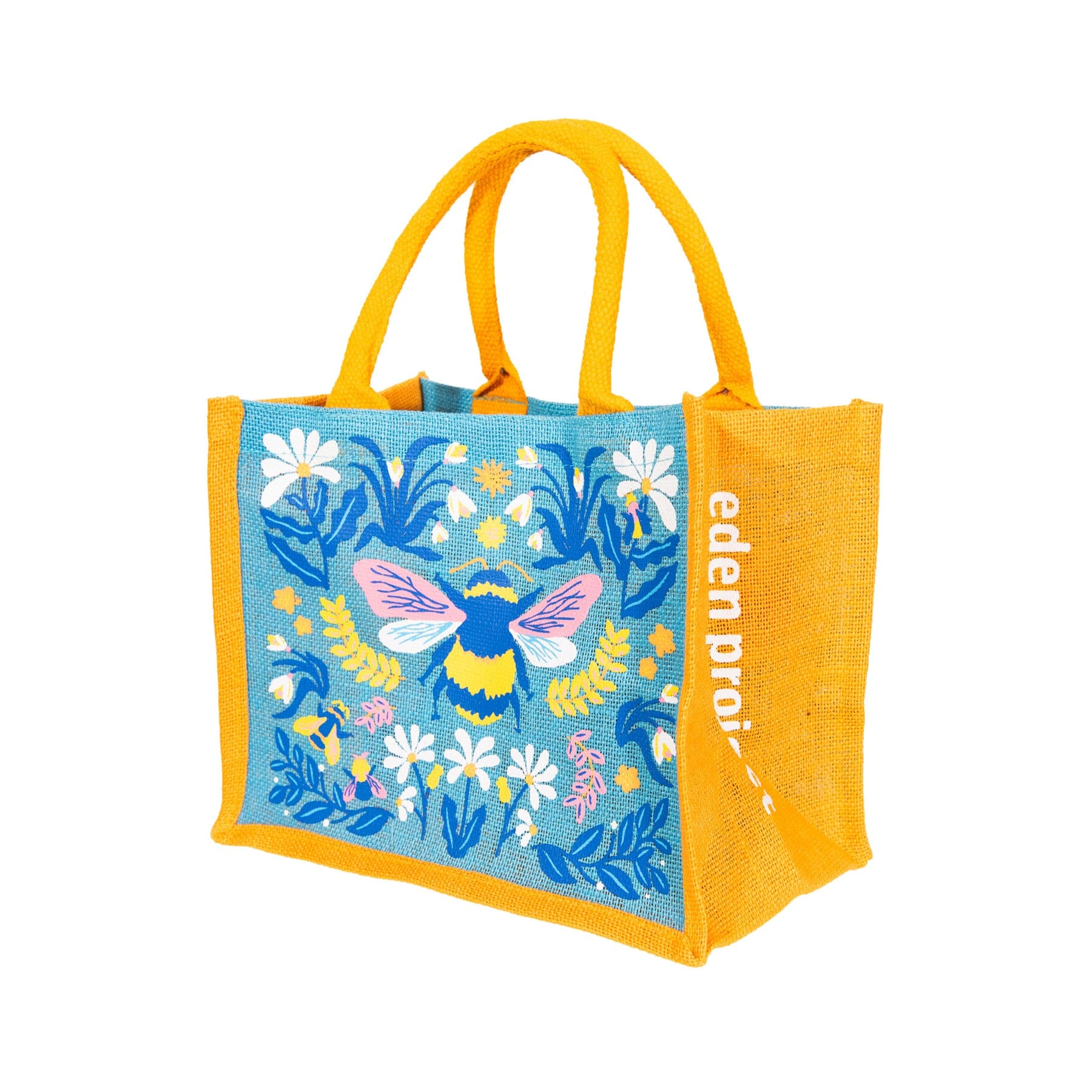 Colorful reusable shopping tote bag with floral and butterfly print on blue background and yellow handles displayed on white background.