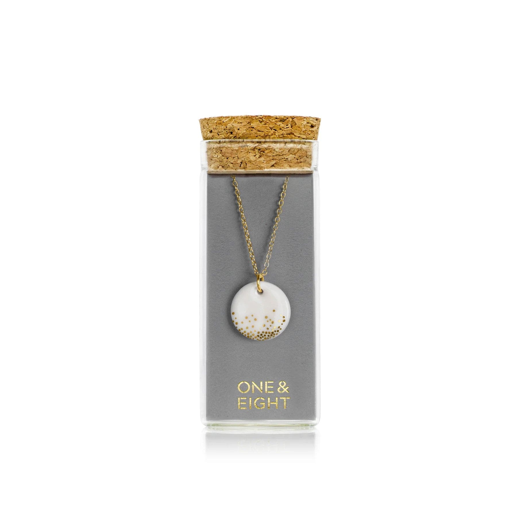 Elegant gold necklace with a white circular ceramic pendant featuring gold speckle design, presented in a minimalist gray packaging with 'ONE & EIGHT' branding, isolated on a white background.