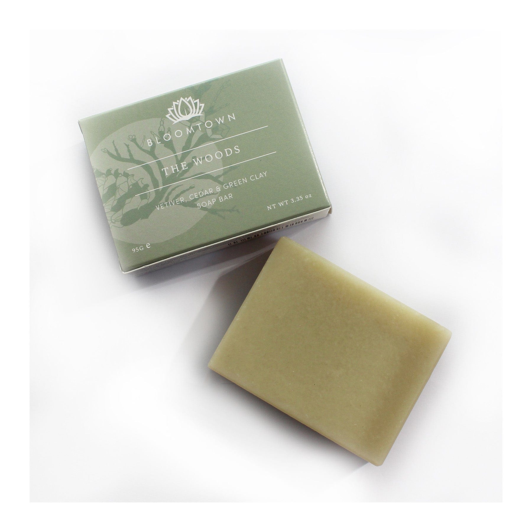 Bloomtown The Woods vetiver, cedar and green clay soap bar next to its packaging on white background