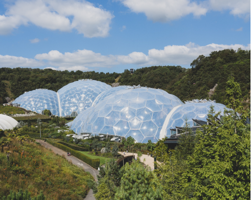 Biomes structures at Eden Project, ecological architecture, geodesic domes, Cornwall, environmental conservation, sustainable tourism attraction, lush greenery.