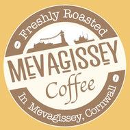 Alt text: Logo of Mevagissey Coffee with text "Freshly Roasted in Mevagissey, Cornwall," featuring stylized graphics of buildings and a ship, set against a creamy yellow background.
