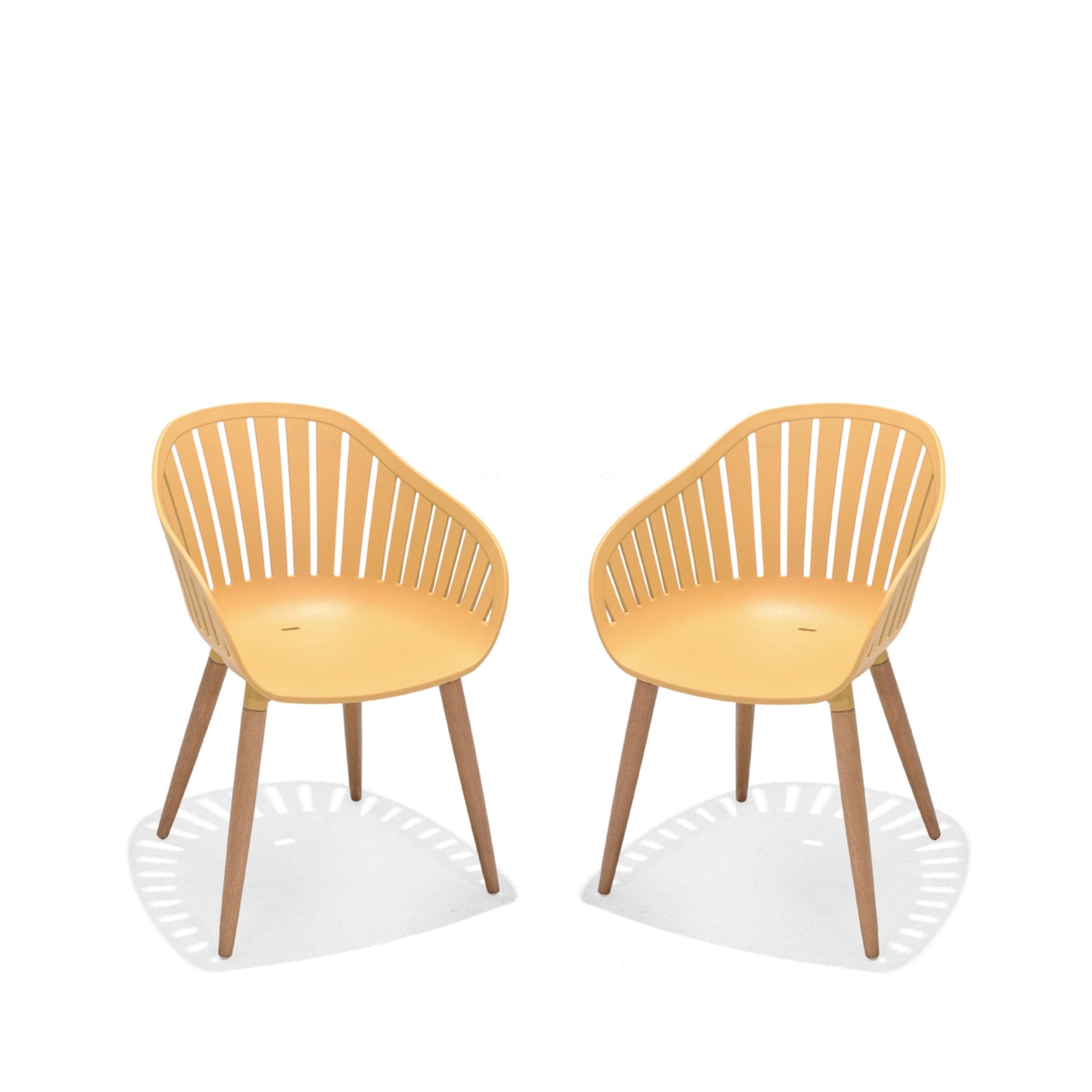 Two modern mustard yellow dining chairs with wooden legs and slatted backrest on white background