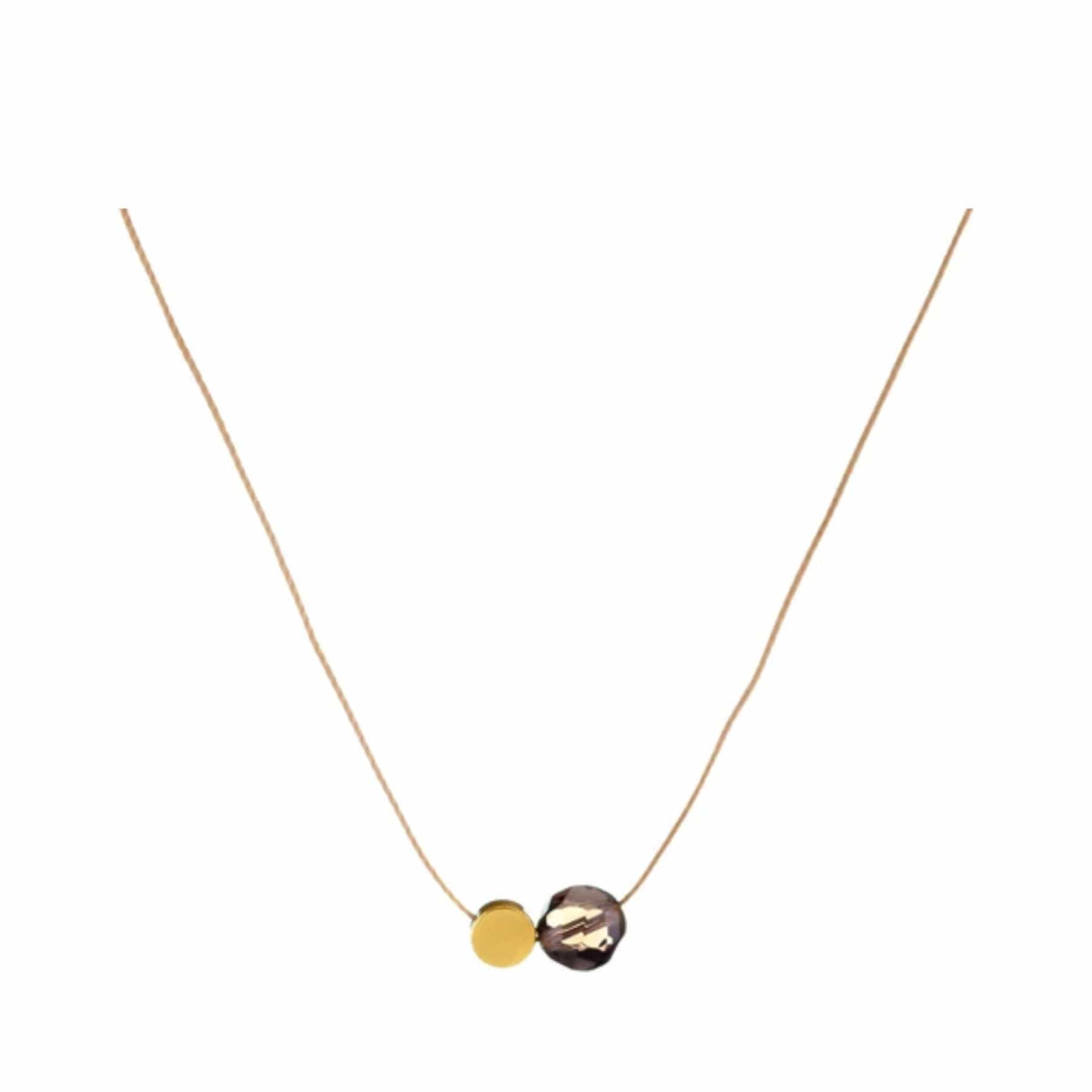 Elegant gold necklace with two pendants, one solid gold disc and one larger gemstone, on a white background.