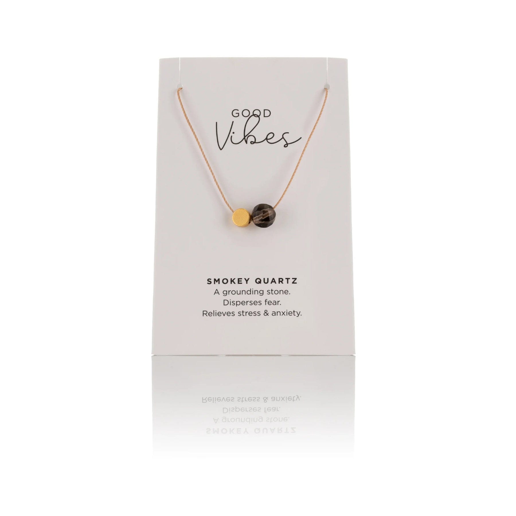 Smokey quartz necklace displayed on white packaging with "Good Vibes" text, description stating it is a grounding stone that disperses fear, relieves stress and anxiety.